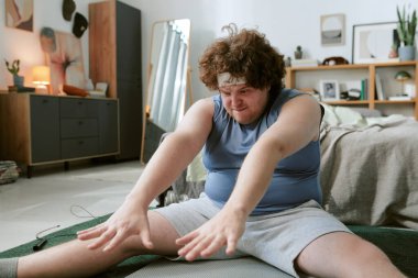 Yatak odasında sabah esneme hareketleri yoğun bir odaklanma ve kararlılıkla yapılıyor. Çevreler arasında düzgün düzenlenmiş mobilyalar ve rahat bir ortam sağlayan dekor yer alıyor