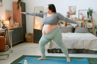 Yoga dengesi kuran kişi rahat, iyi dekore edilmiş bir yatak odasında huzurlu ve sağlıklı bir yaşam tarzına odaklanıyor.