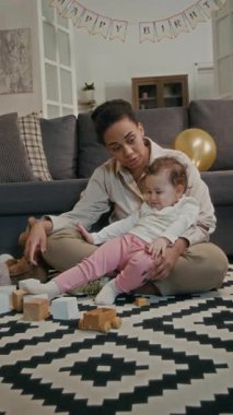 Sevgili annenin küçük kızıyla sohbet ederken ve akıllı telefonuyla selfie çekerken çekilmiş dikey bir fotoğrafı.