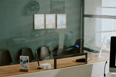 Gösterişli ahşap tezgahlar ve cam bölümlerin yer aldığı modern bankacılık resepsiyon alanı, ofis dekorasyonu çerçeveli resimler ve çağdaş tablo dekorları içeriyor