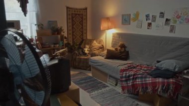 İçinde gri kanepe, antika televizyon ve el yapımı sanat eserleri olan küçük ve rahat bir oturma odasının içi çekilen insanlar yok.