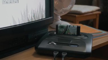 Yakın plan hiç kimse CRT TV 'ye bağlı oyun kartuşlu retro konsolu siyah-beyaz oyun oyunu göstererek çekmez