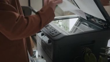 Ofis yazıcısına kağıt koyan tanınmayan kadın ofis çalışanının görüntüsünü kapat, sonra kapağı kapat ve belgeyi taramak için düğmeye bas