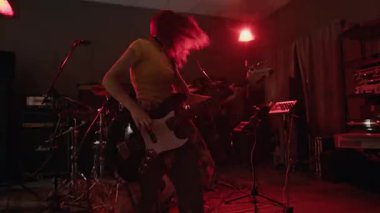 Müzik stüdyosunda elektro gitarla titreyen, titreyen, titreyen ve titreyen genç bir kız.