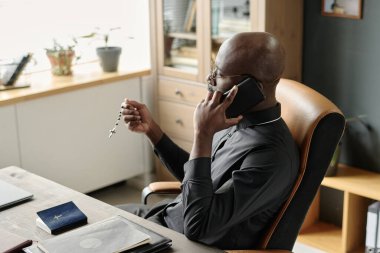Tanımlanamayan papazın elinde tespih sayarken yüksek açılı fotoğrafı.
