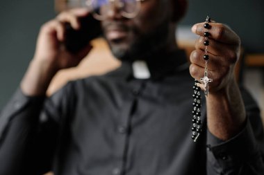 Tanımlanamayan papazın elinde dua eden güzel boncuklar.