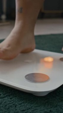 Yatak odasında dijital beyaz ölçekte yürüyen tanınmayan bir kadının dikey görüntüsü.