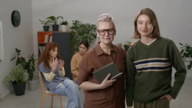 Terapiste giderken kameraya poz veren gülümseyen bir kadının portresi.