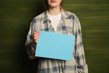 Elinde boş mavi bir poster kağıdı tutan biri. Reklam ya da ürün sergileri için resim modelleme ve proje oluşturma. Ürün maketi. Tasarım konsepti.