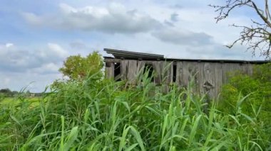Güçlü bir fırtına sırasında, dökülen bir barakanın kıvrımlı demiri hareket eder.
