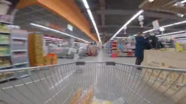 Marketten alışveriş arabası geçiyor. Alışveriş sepetinin içinde. Zaman ayarlı. Hiperlapse