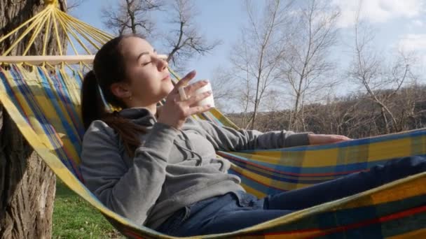 Kız Doğada Bir Hamakta Yatıyor Çay Içiyor — Stok video