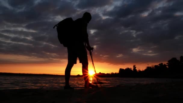 Silhouette Eines Mannes Der Mit Einem Metalldetektor Strand Entlang Geht — Stockvideo