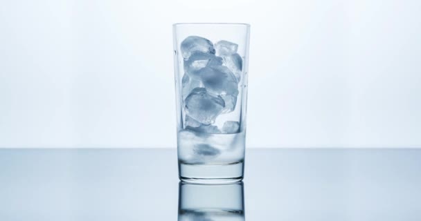 가벼운 배경에 유리잔에 얼음을 녹이는 미터기 — 비디오
