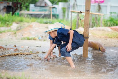 Çocuk çamur çukurunda ve kumda oynamaktan zevk alıyor, doğanın her mevsiminde oyun bahçesini kucaklıyor.