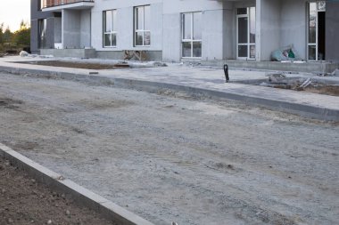 Konut evlerinin yakınında yeni bir yol inşaatı. Yeni şehir binası