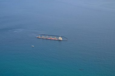 Cebelitarık sahilinde batık bir gemi ve etrafında petrol bariyeri var.