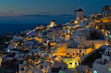 Aydınlatılmış binalarla Ia şehrinin üzerinde gün batımı