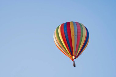 Pilot balonun içindeki havayı hafifletmek için alevler saçarken sıcak hava balonu yükseliyor.