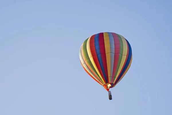 パイロットが風船の内部の空気を明るくするために炎を加えるように上昇する熱気球 — ストック写真