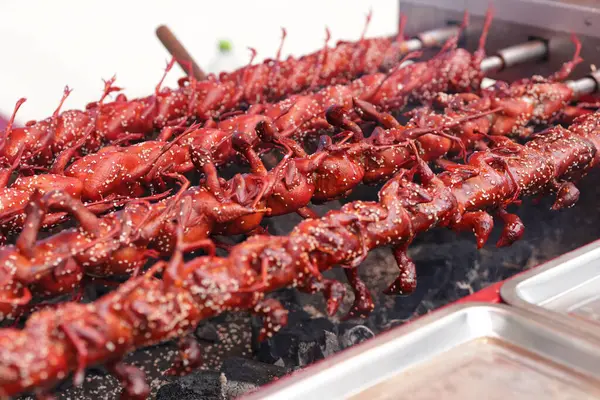 Sobanın üzerine beyaz susam tohumları serpiştirilmiş ızgara bıldırcın. Pazarda satılık kızarmış bıldırcın..