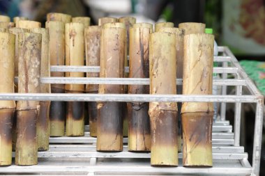 Bambu tüplere doldurulmuş hindistan cevizi sütüyle yapış yapış pilav ve pişirilene kadar ızgara. Birçok bambu tüp yapışkan pirinç pazarda satılıktır..