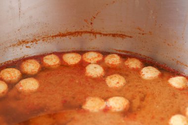 Kırmızı çorbada yüzen köfteler. Köfteler Khanom Jeen 'in sosunda yüzüyor..