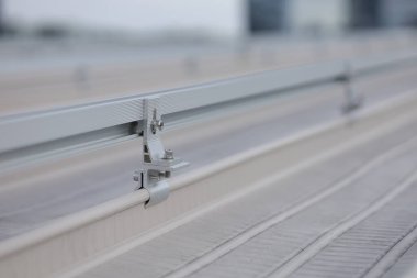 Güneş panellerini desteklemek için raylar bağlanıyor. Çatı sırtına demiryolu seti monte ediliyor.