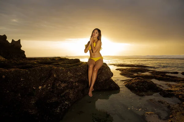 Mooie Aziatische Vrouw Zittend Rots Met Gele Bikini Aan Slank — Stockfoto
