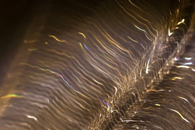 Hafif bokeh. Bokeh, arka planda yanıp sönen bulanık sarı ışıklar. Sarı-kahverengi tonlarda soyut bulanık arkaplan. Işık hareketi efekti.