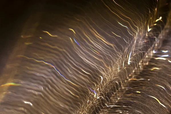 Hafif bokeh. Bokeh, arka planda yanıp sönen bulanık sarı ışıklar. Sarı-kahverengi tonlarda soyut bulanık arkaplan. Işık hareketi efekti.