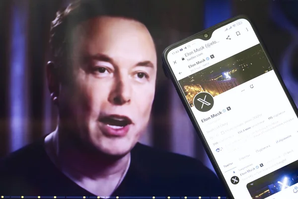 Ukrayna, 2023. Elon Musks Twitter profili akıllı telefondan ve Elon Musk arka planda.