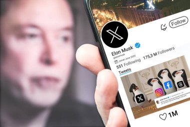 Poltava, Ukrayna - 5 Mart 2024: Elon Musk Twitter profili sayfası yeni tweeti ile akıllı telefon ekranında. Arka planda Elon Musk 'ın çözülmüş bir portresi var. Editör illüstrasyon fotoğrafçılığı.