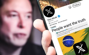 Poltava, Ukrayna - 26 Nisan 2024. Elon Musk Twitter profili sayfasında elinde akıllı telefon var. Arka planda Elon Musk 'un odaksız bir portresi var..