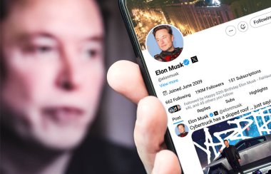 Ukrayna. Poltava. 17 Temmuz 2024. Elon Musk profili akıllı telefon ekranında. Mesajlı yeni tweet. Siber kamyonun çatısı eğimli. Arka planda Elon Musk 'un odaksız bir portresi var..