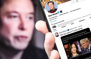 Ukrayna. Poltava. 26 Temmuz 2024. Elon Musk 'ın profili akıllı telefon ekranında. Mesajlı yeni tweet. - Evet. Arka planda Elon Musk 'un odaksız bir portresi var..