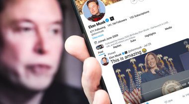 Ukrayna. Poltava. 27 Temmuz 2024. Elon Musk 'ın profili akıllı telefon ekranında. Mesajlı yeni tweet. Arka planda Elon Musk 'un odaksız bir portresi var..
