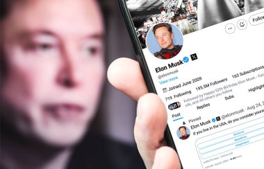Poltava, Ukrayna - 24 Ağustos 2024. Elon Musk Twitter profili sayfasında elinde akıllı telefon var. Arka planda Elon Musk 'un odaksız bir portresi var..