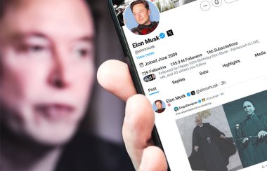 Poltava, Ukrayna - 30 Ağustos 2024. Elon Musk Twitter profili sayfasında elinde akıllı telefon var. Arka planda Elon Musk 'un odaksız bir portresi var..