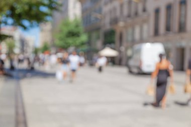 Şehrin arka planı bulanık ve yürüyen insanlar.