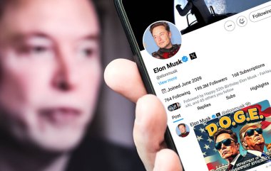 Ukrayna. Boryspil. 28 Eylül 2024. Elon Musk profili akıllı telefon ekranında. Mesajlı yeni tweet. Arka planda Elon Musk 'un odaksız bir portresi var..