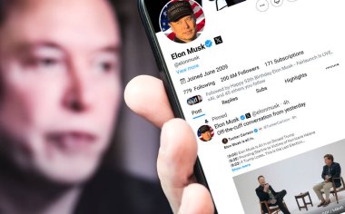 Poltava, Ukrayna, Ekim 08, 2024. Elon Musk Twitter profili, akıllı telefon ekranında Tucker Carlson 'la bir konuşma hakkında yeni bir tweet atıyor. Arka planda Musk 'ın odaksız bir portresi var..