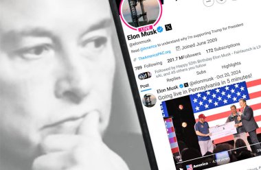 Ukrayna. Poltava. 20 Ekim 2024. Elon Musk profili akıllı telefon ekranında. Mesajlı yeni tweet. Arka planda Elon Musk 'un odaksız bir portresi var..