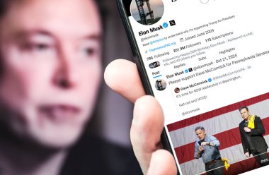 Ukrayna. Poltava. 21 Ekim 2024. Elon Musk profili akıllı telefon ekranında. Mesajlı yeni tweet. Arka planda Elon Musk 'un odaksız bir portresi var..