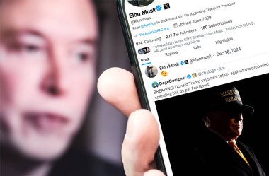 Poltava, Ukrayna - 18 Aralık 2024. Elon Musk Twitter profili sayfasında elinde akıllı telefonuyla yeni bir tweet var. Arka planda Elon Musk 'un odaksız bir portresi var..