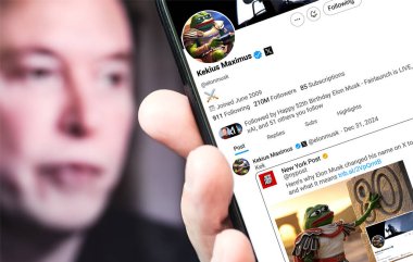 Poltava, Ukrayna - 31 Aralık 2024. Elon Musk Twitter profili sayfasında elinde akıllı telefonuyla yeni bir tweet var. Arka planda Elon Musk 'un odaksız bir portresi var..