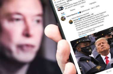 Poltava, Ukrayna - 1 Ocak 2025. Elon Musk Twitter profili sayfasında elinde akıllı telefonuyla yeni bir tweet var. Arka planda Elon Musk 'un odaksız bir portresi var..