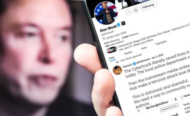 Poltava, Ukrayna - 2 Ocak 2025. Elon Musk Twitter profili sayfasında elinde akıllı telefonuyla yeni bir tweet var. Arka planda Elon Musk 'un odaksız bir portresi var..