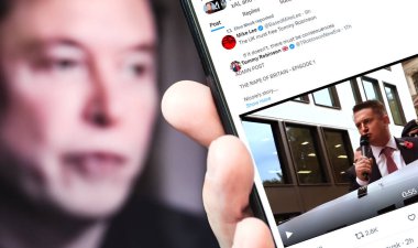 Poltava, Ukrayna - 2 Ocak 2025. Elon Musk Twitter profili sayfasında elinde akıllı telefonuyla yeni bir tweet var. Arka planda Elon Musk 'un odaksız bir portresi var..