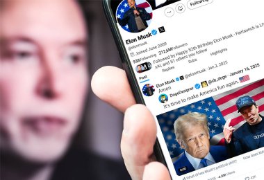 Poltava, Ukrayna - 16 Ocak 2025. Elon Musk Twitter profili sayfasında elinde akıllı telefonuyla yeni bir tweet var. Arka planda Elon Musk 'un odaksız bir portresi var..